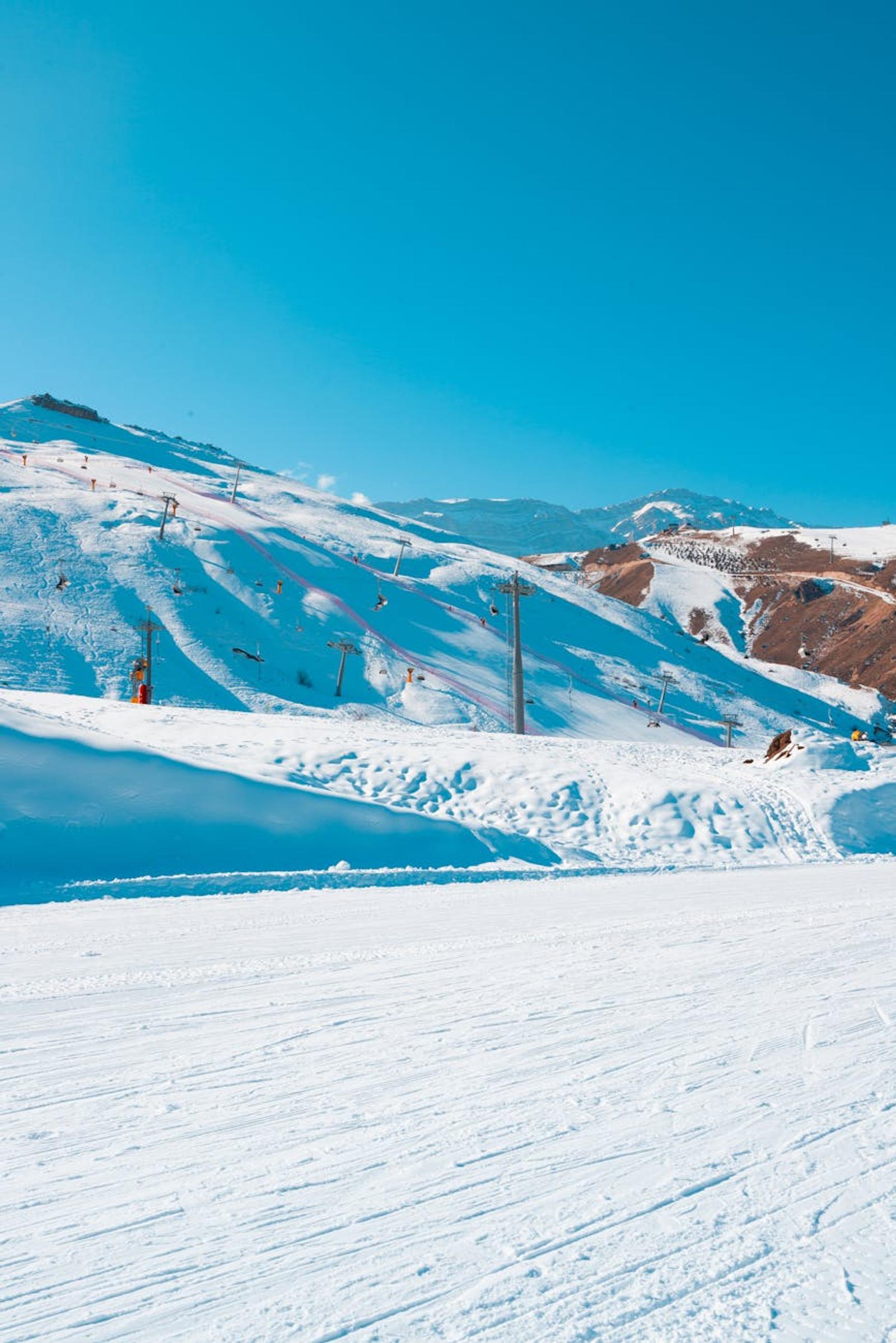 Capture the serene beauty of Shahdag's snow-covered mountains with clear blue skies