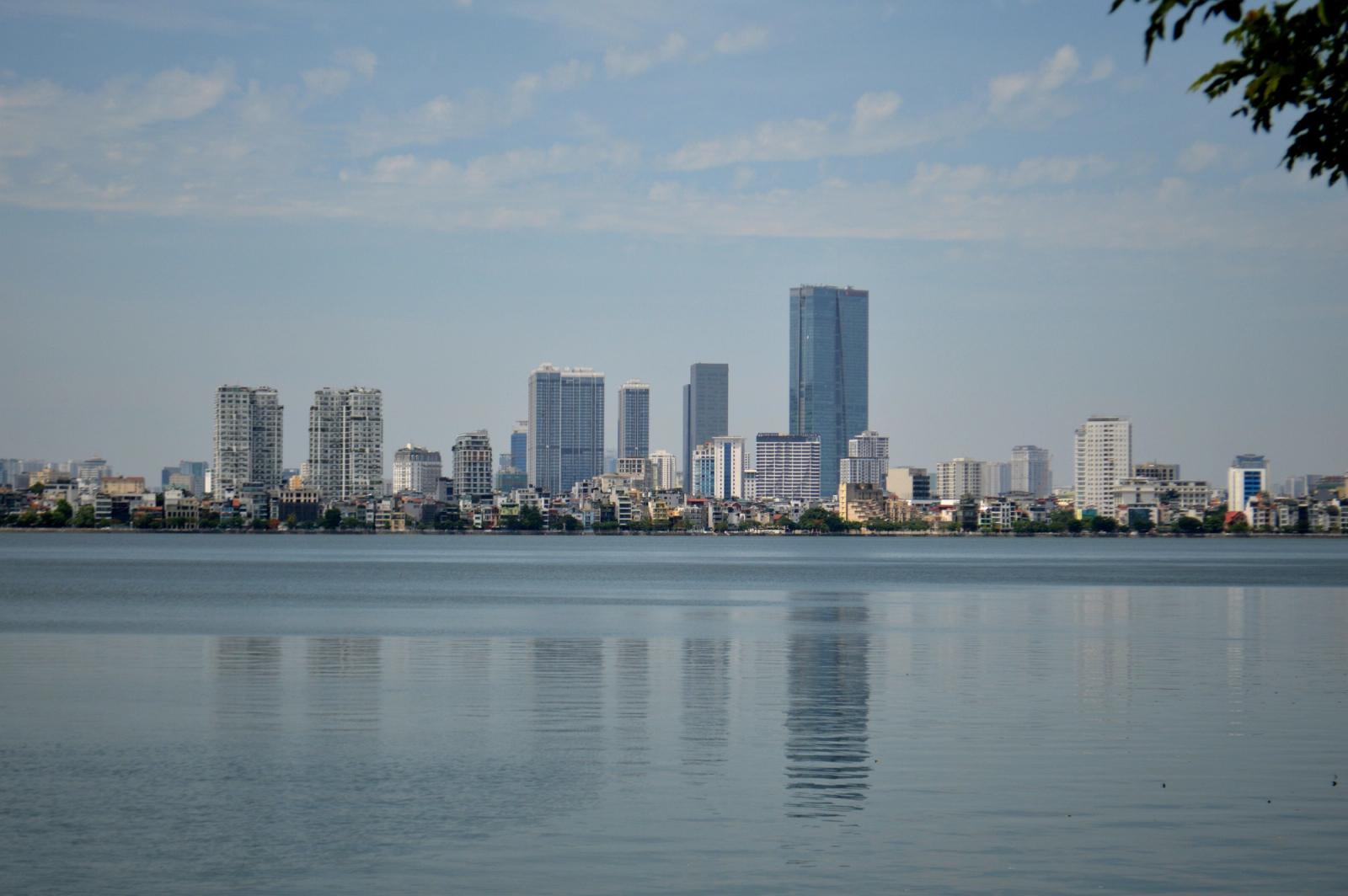 Panoramic view of Hanoi's skyline reflected in West Lake during a clear day