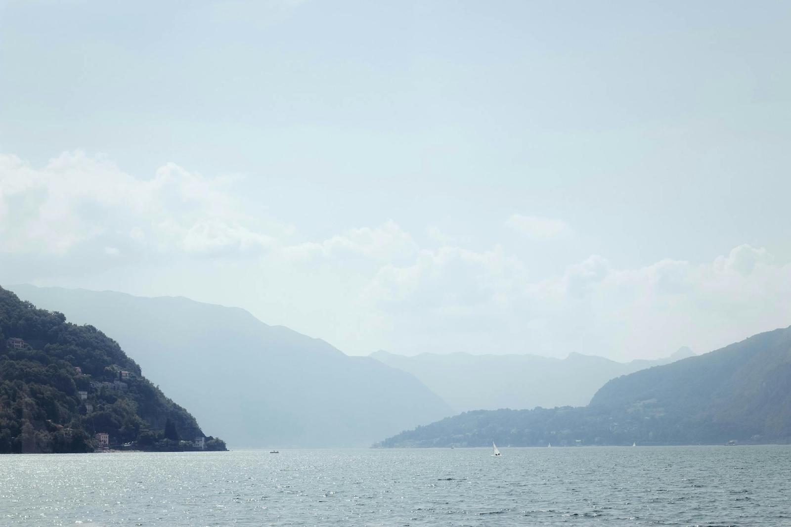 A hazy lake framed by mountain ridges fading into the distance
