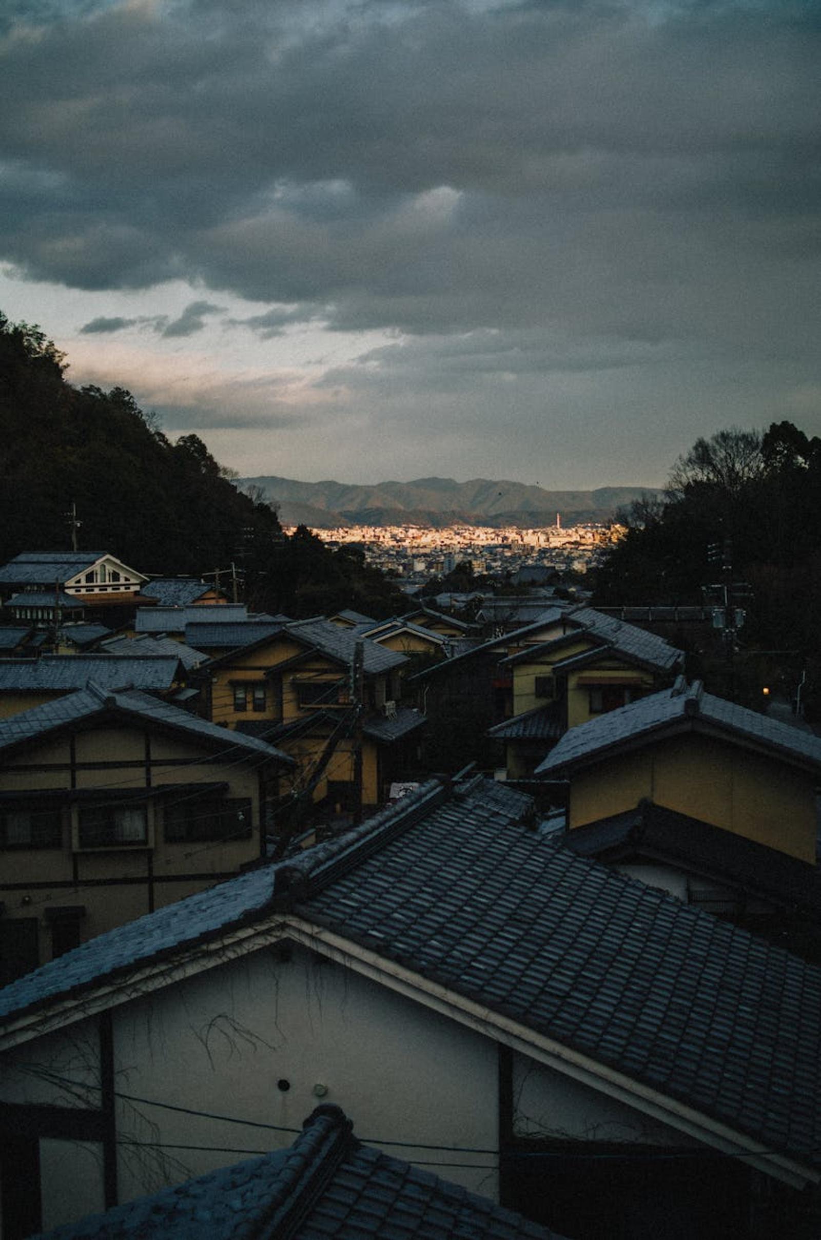 Tiled rooftops overlooking a hillside town lit up at dusk