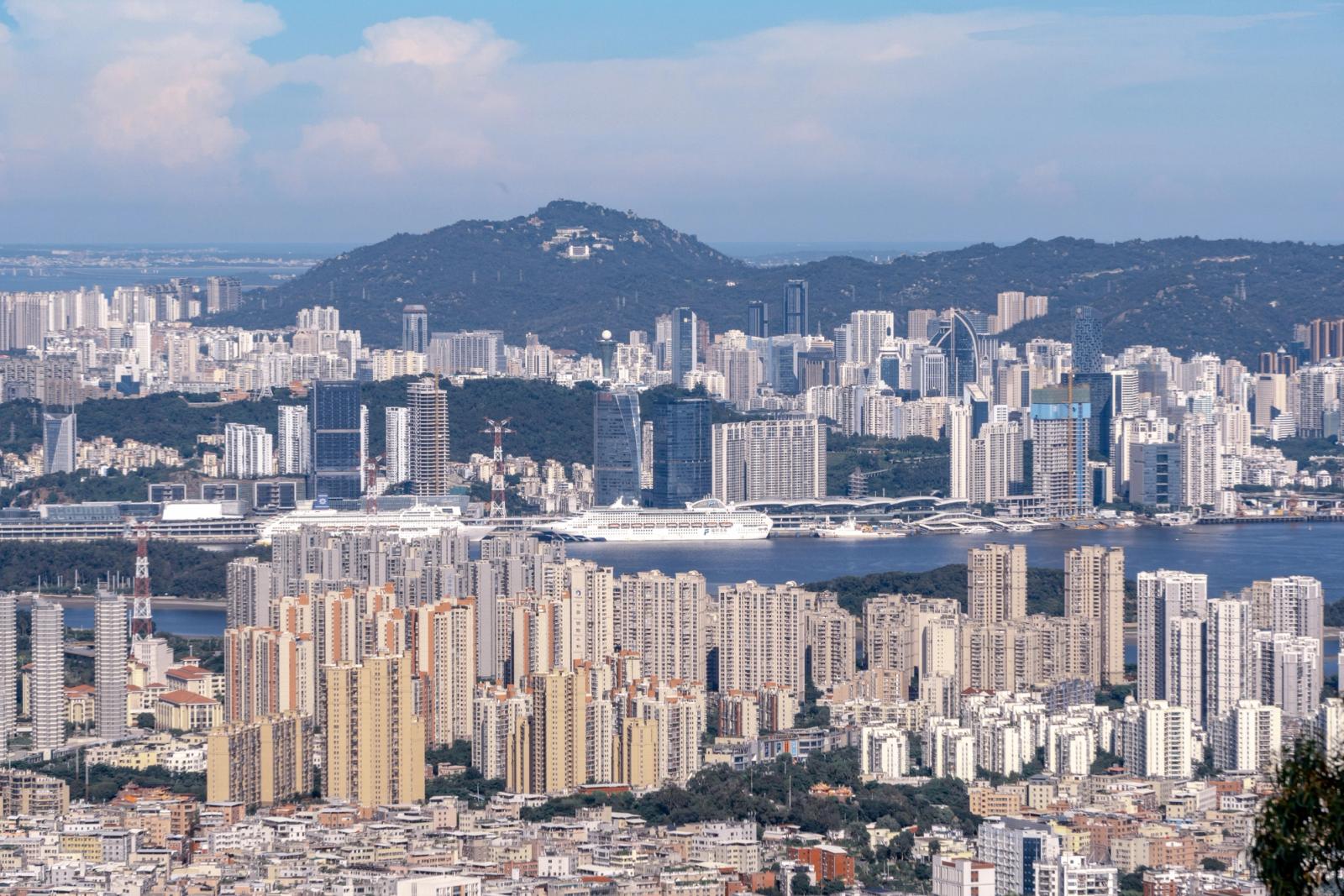 Panoramic view of Hong Kong's skyline showcasing modern skyscrapers, hills, and harbor on a clear day