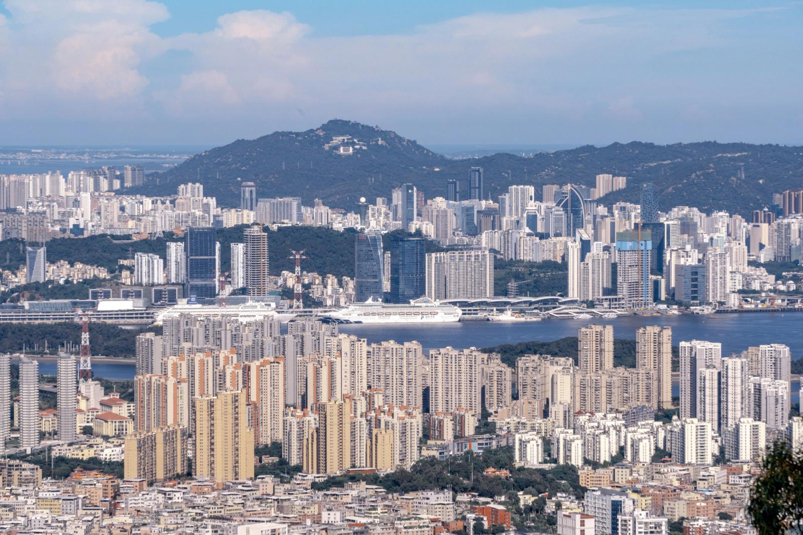 Panoramic view of Hong Kong's skyline showcasing modern skyscrapers, hills, and harbor on a clear day