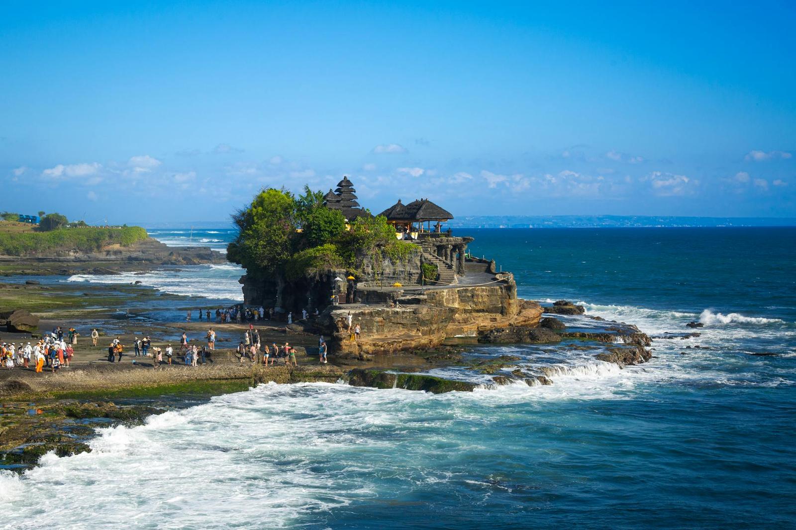 Explore the iconic Tanah Lot Temple perched on a rocky coastline in Bali, Indonesia