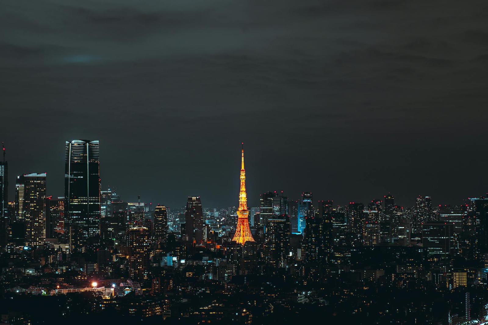 Tokyo Tower glowing orange over a city skyline at night