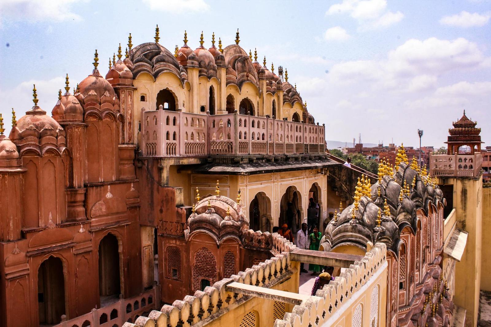 Rows of domed rooftop turrets on a pink sandstone palace