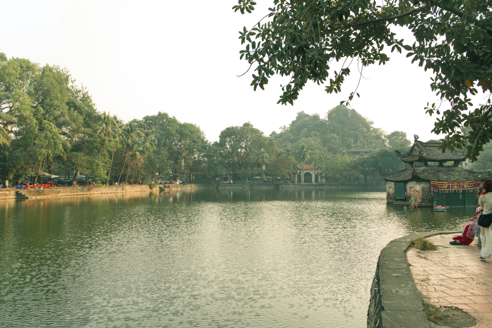 Tranquil scene at West Lake in Hanoi, capturing lush greenery and traditional architecture
