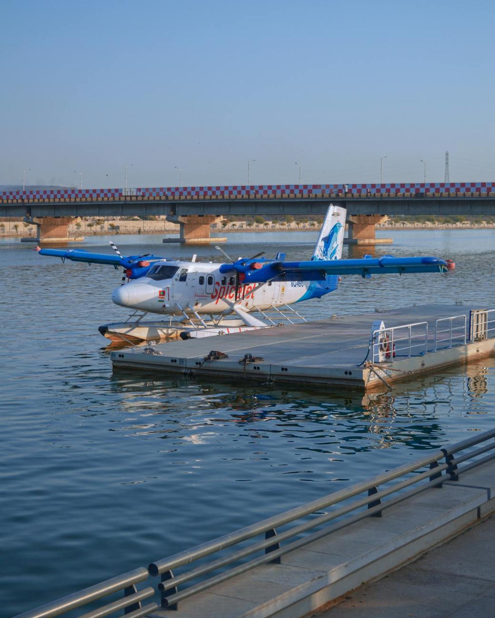 Seaplane at floating dock on Sabarmati River, Ahmedabad with scenic bridge view