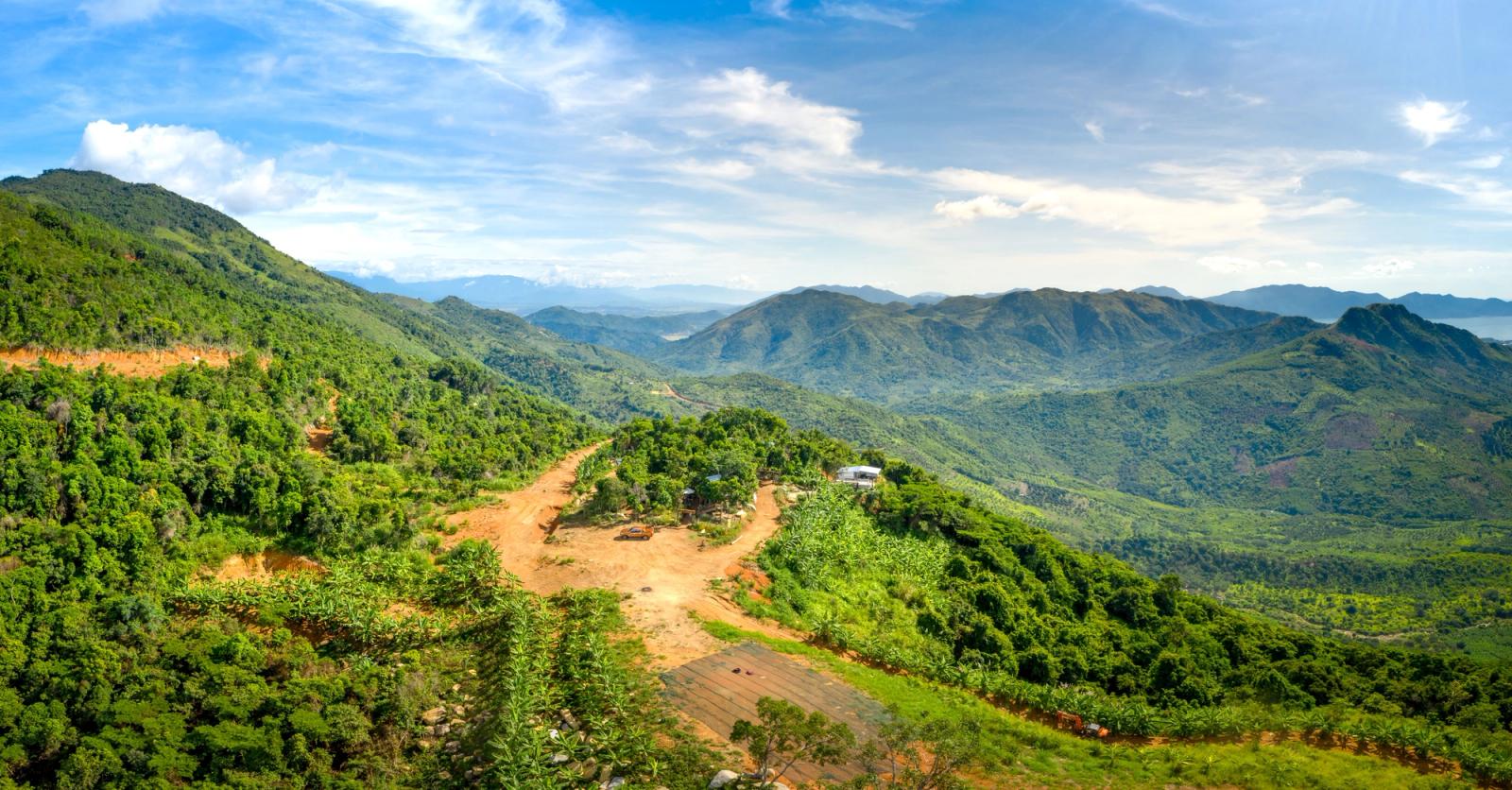 Breathtaking aerial view of verdant mountains and valleys under a clear blue sky