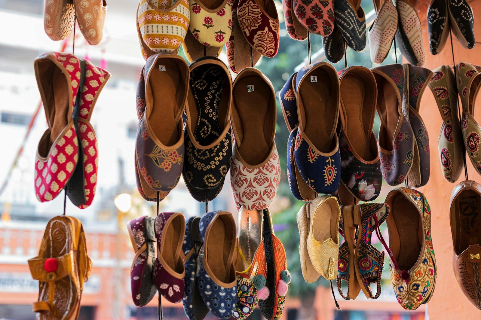 Rows of embroidered leather slippers hanging at a market stall