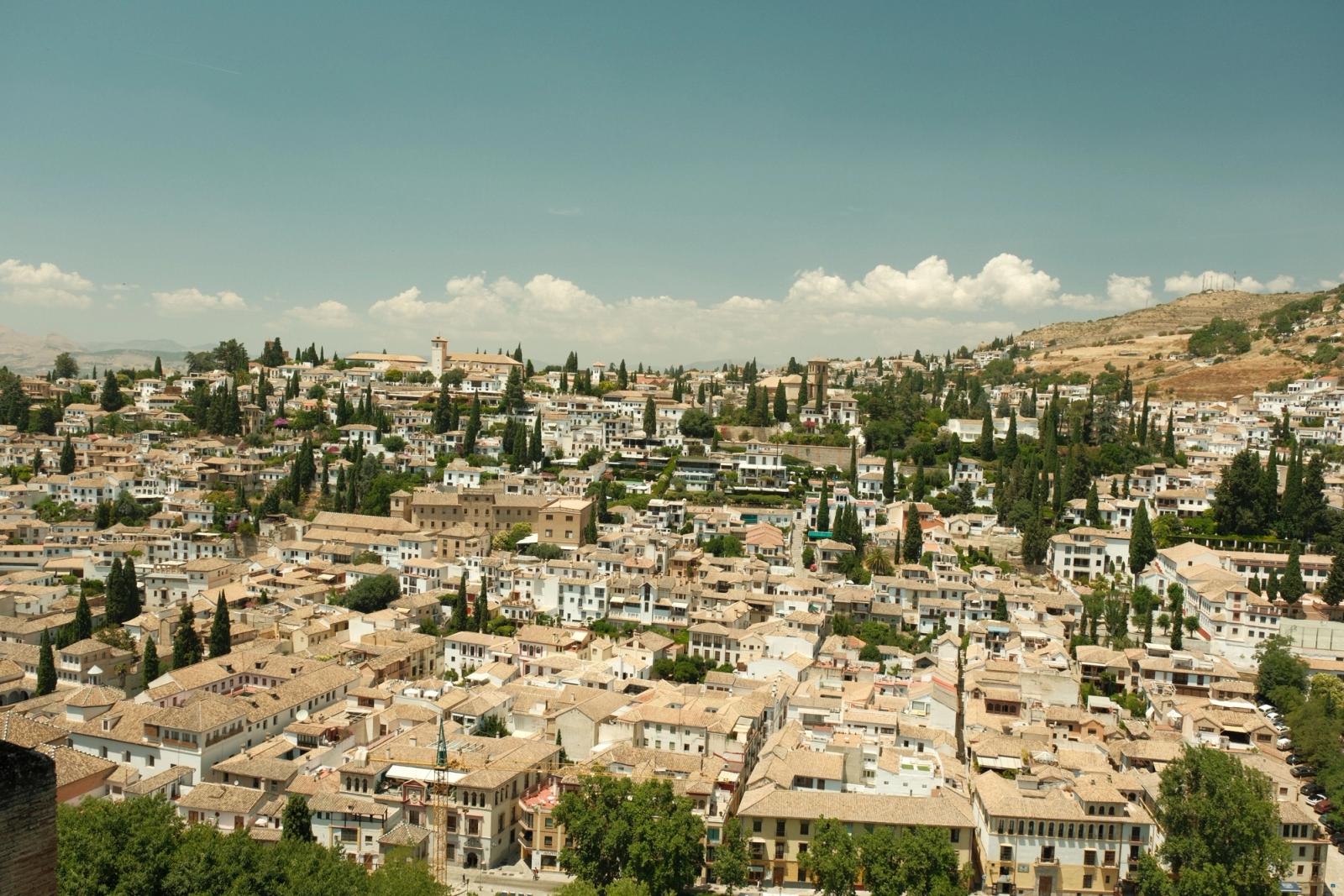 Aerial view of Granada, Spain, showcasing historic architecture and scenic landscape under a clear sky