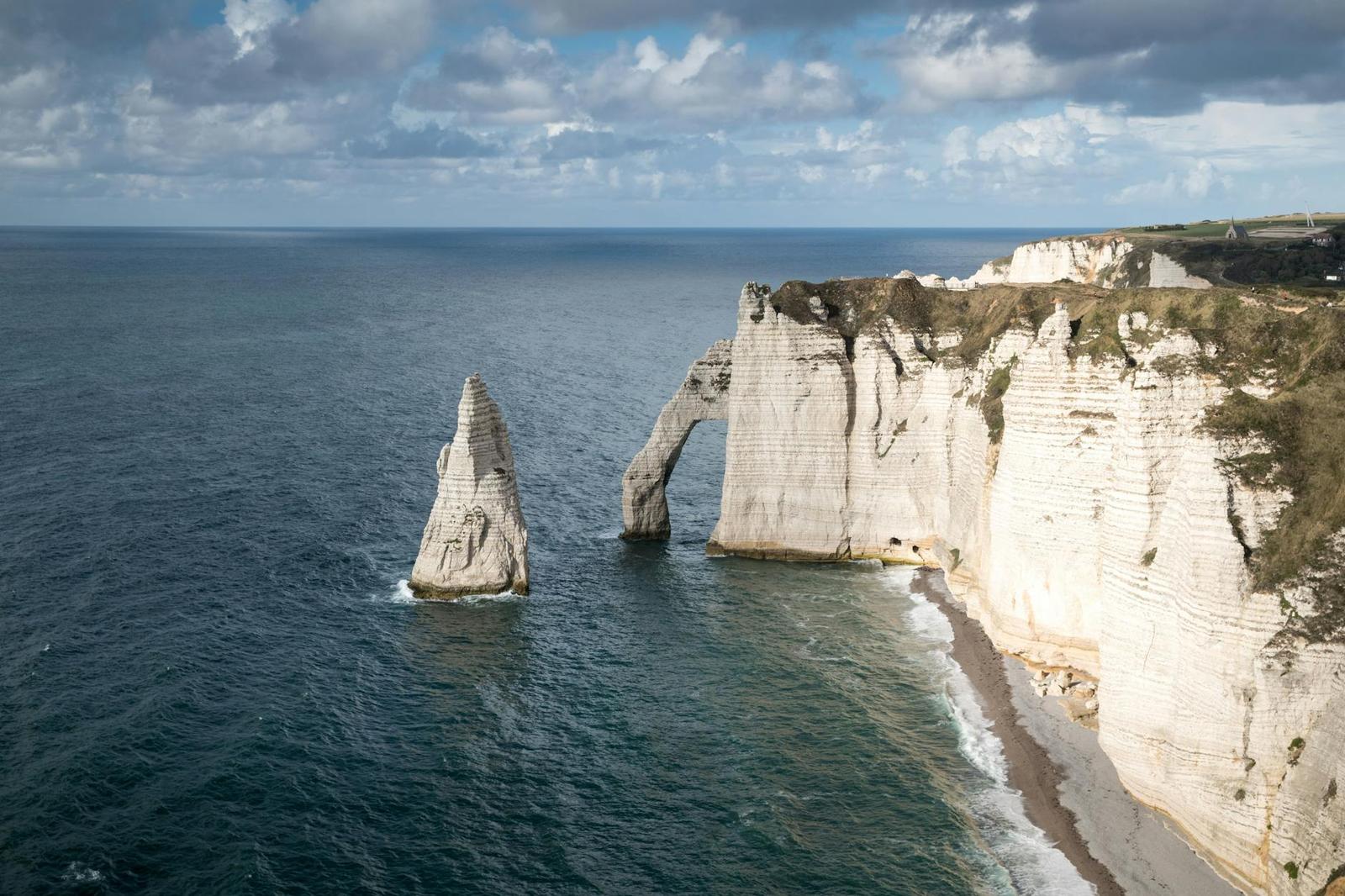 Chalk cliffs and a sea stack viewed from above on a cloudy day