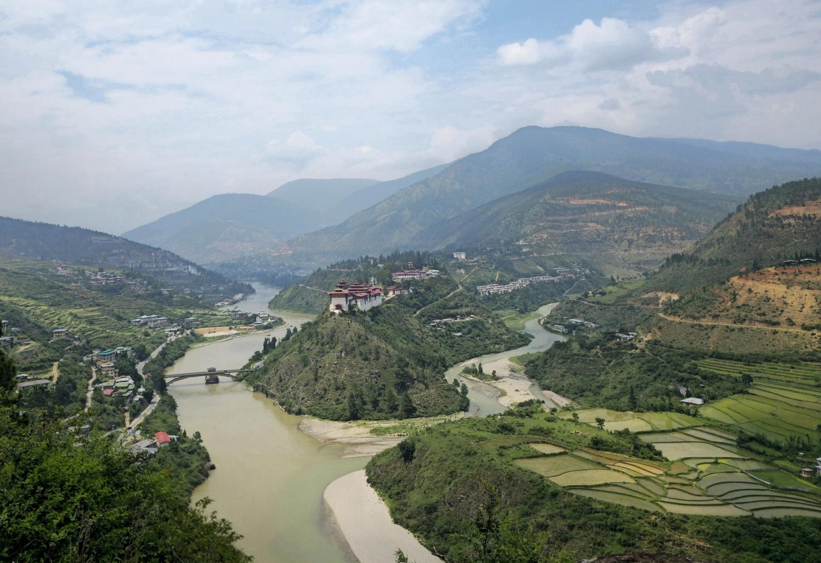 Scenic view of Punakha Valley with Mo Chhu River and rice paddies, lush greenery and distant mountains