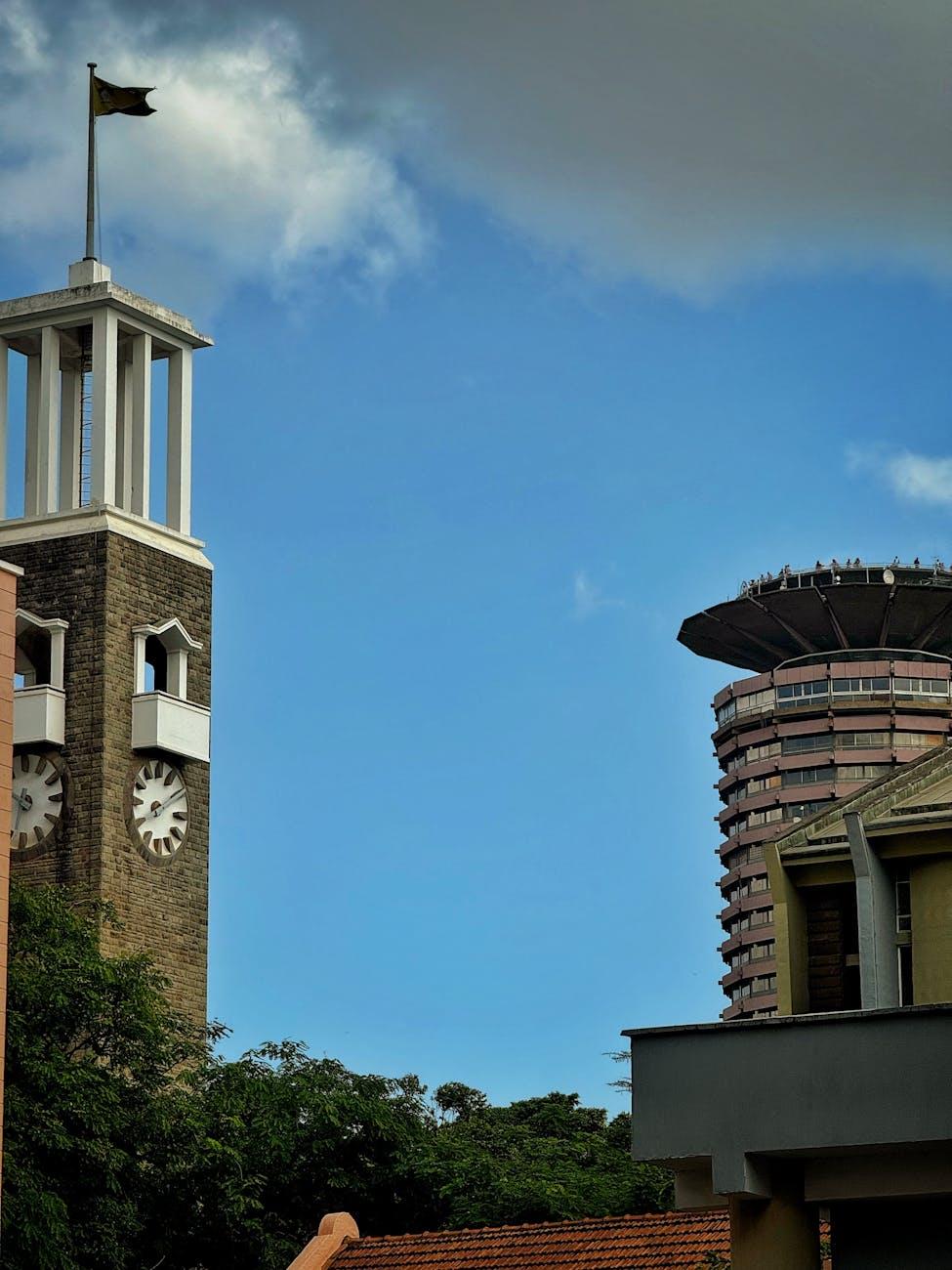 Skyline view of Nairobi with KICC and a historic clock tower under a blue sky