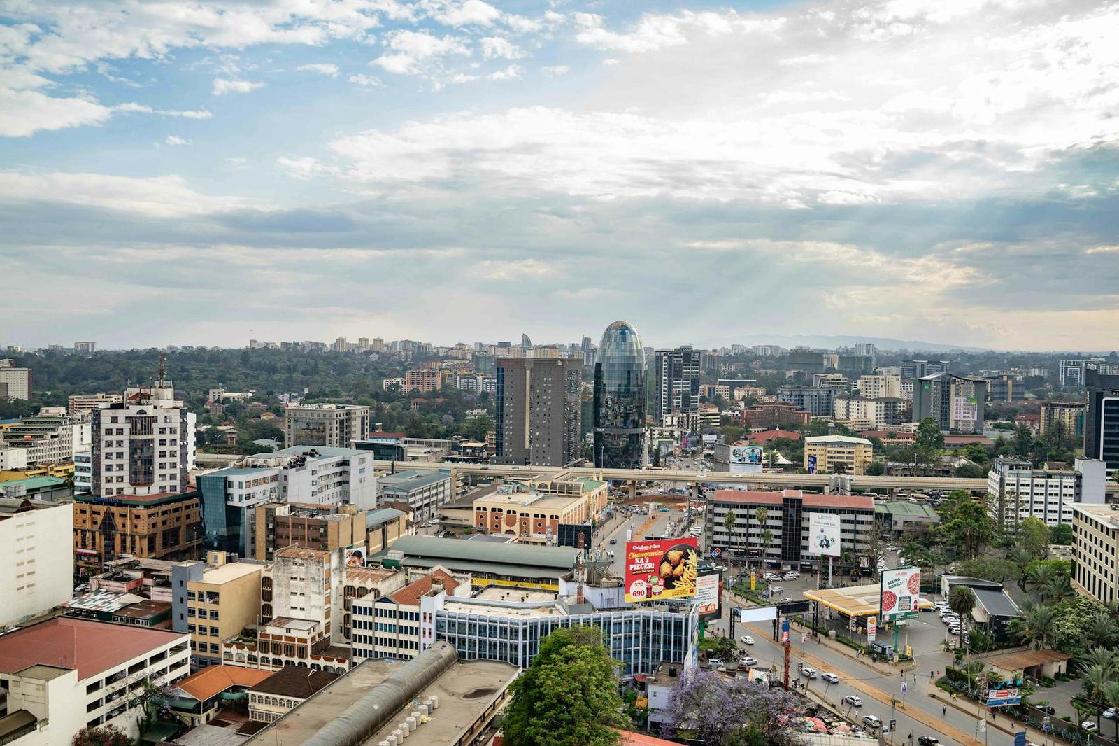 A city skyline with high-rise towers under a partly cloudy sky