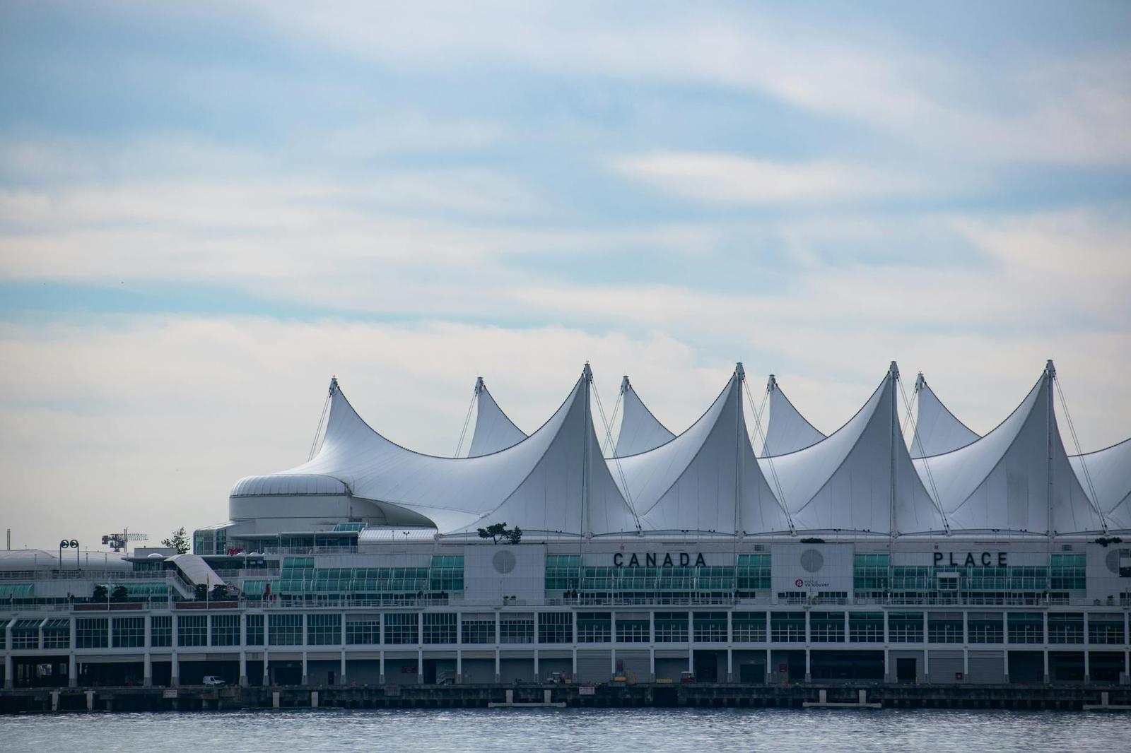 A row of white sail-shaped roofs on a waterfront convention building