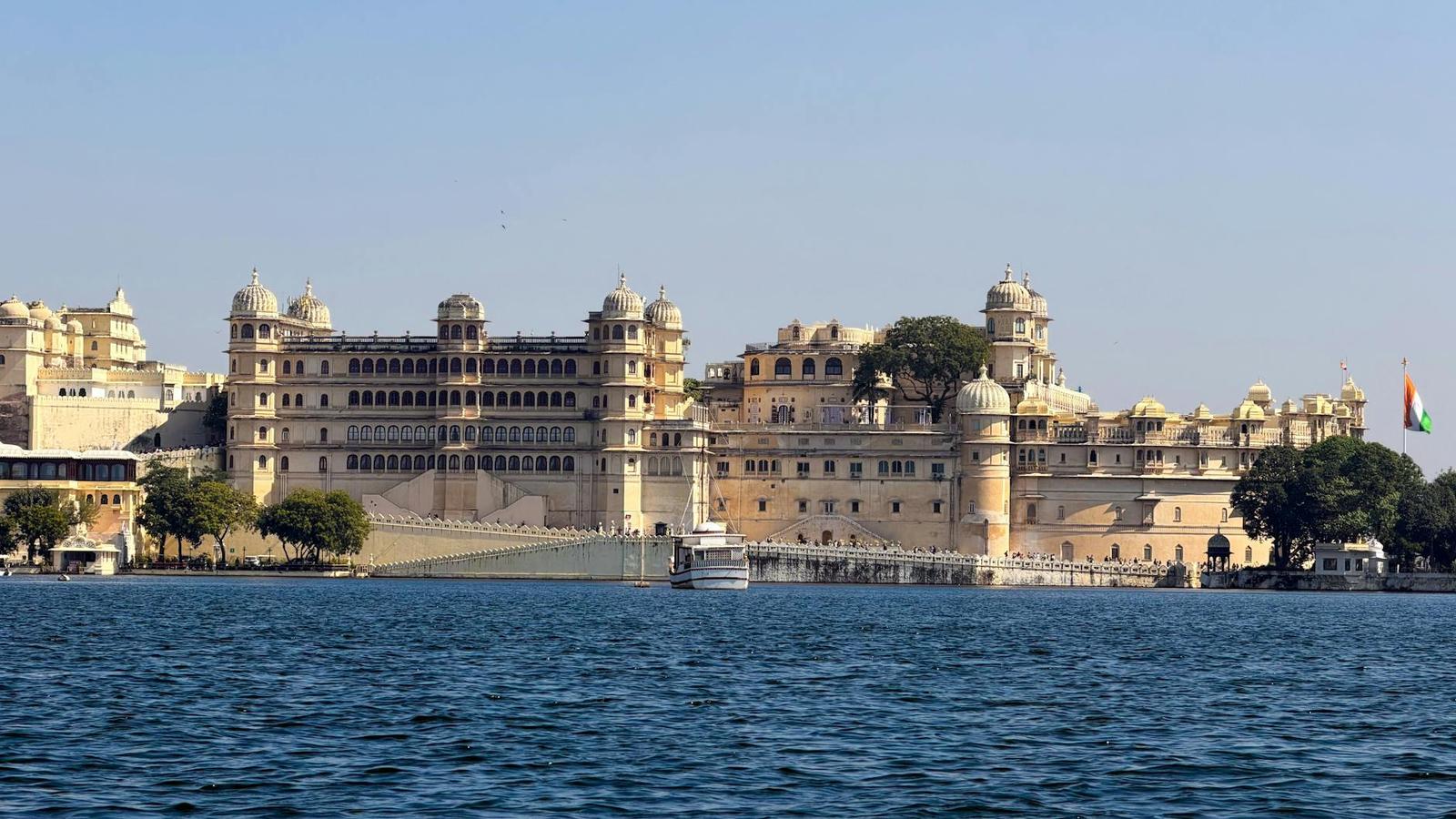 Ornate lakeside palace with domed turrets viewed from the water