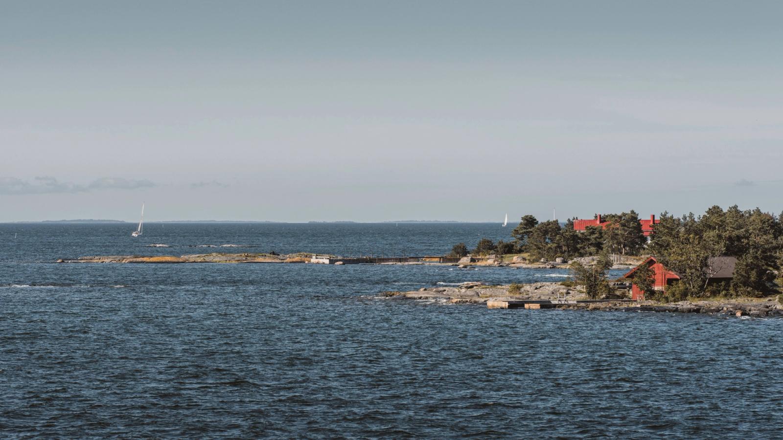 Beautiful view of the Finnish archipelago with sailboats and red wooden houses