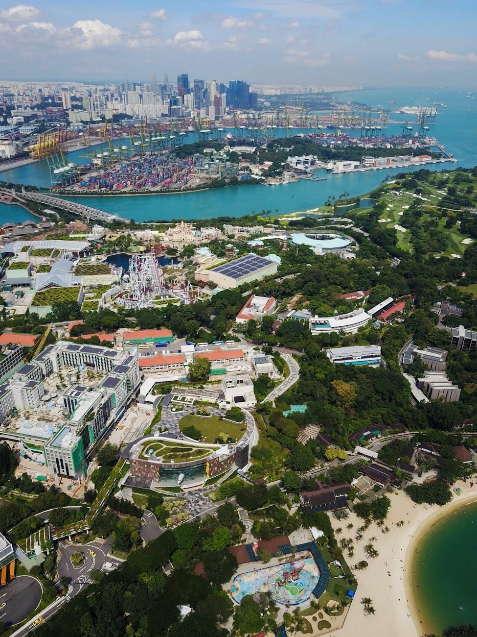 Aerial view of a theme park and beach resort against a city skyline