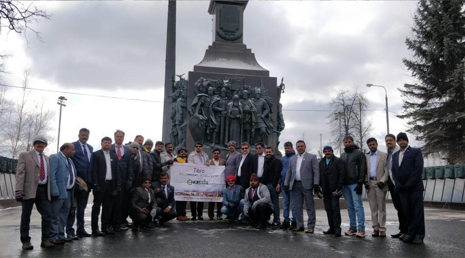 Group of people posing together in front of a historic monument