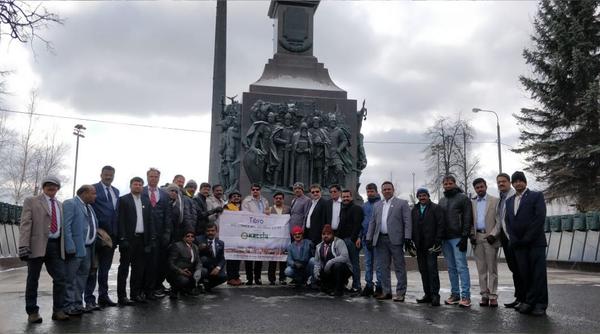Group of people posing together in front of a historic monument