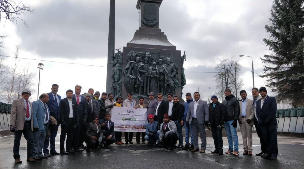 Group of people posing together in front of a historic monument