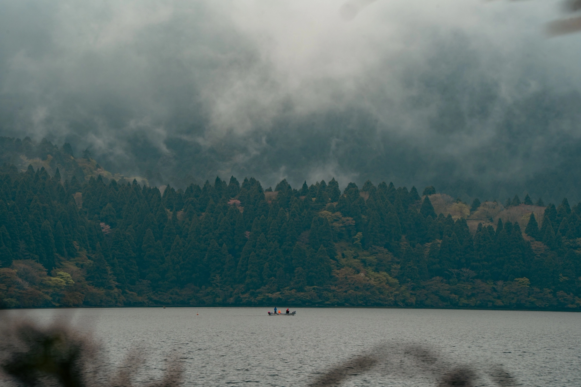 Serene view of Lake Ashi in Hakone, Japan with fog rolling over lush forests
