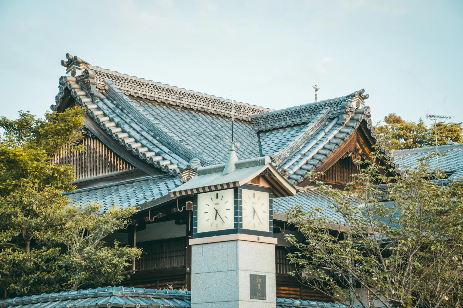 Elegant Japanese temple with traditional architecture and clock tower in sunny Tokyo setting
