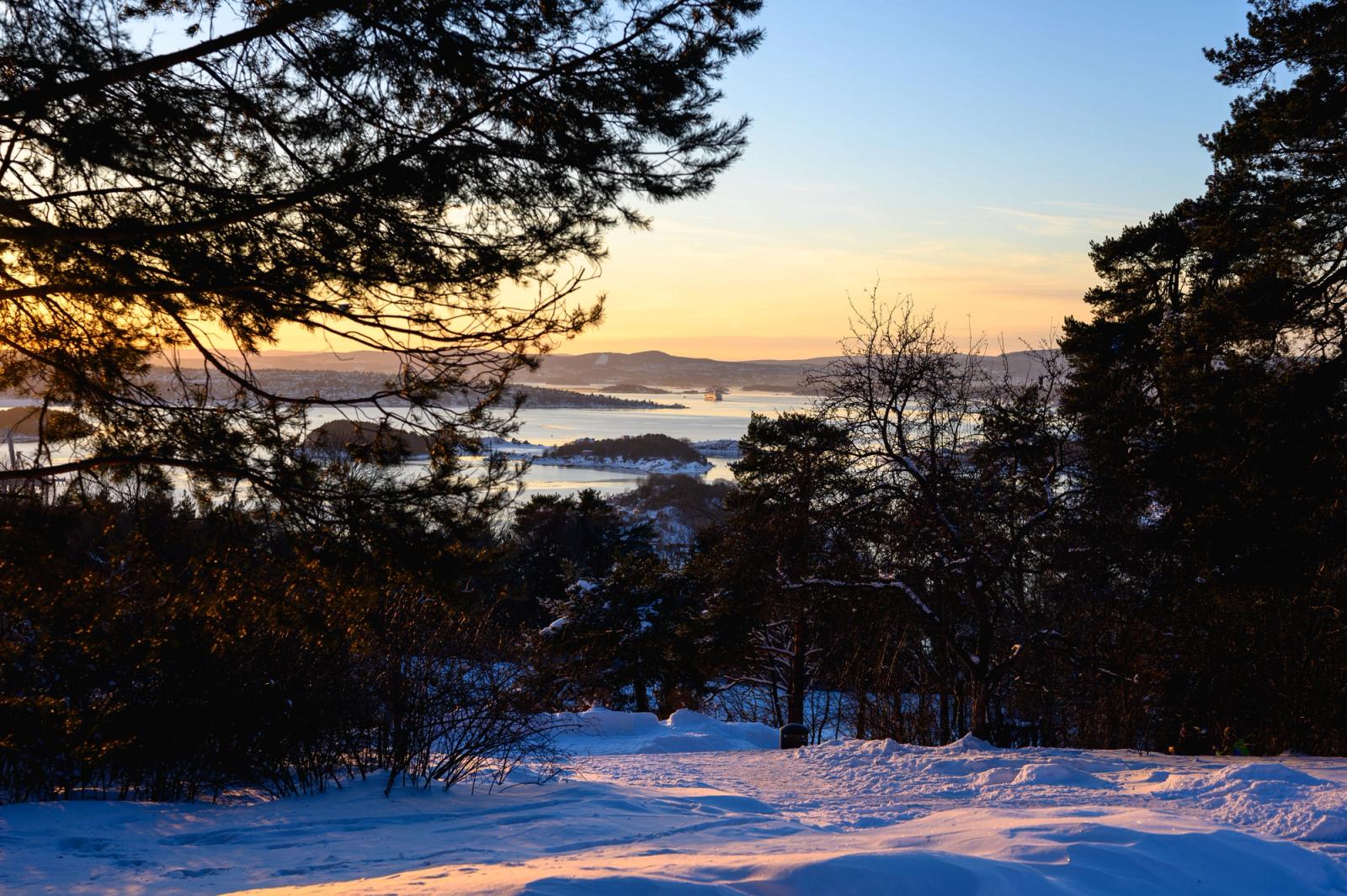 Captivating winter sunset overlooking the snowy landscape and forests near Oslo, Norway