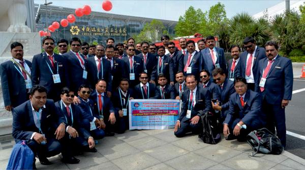 People gather for a group photo outside a Chinese expo.