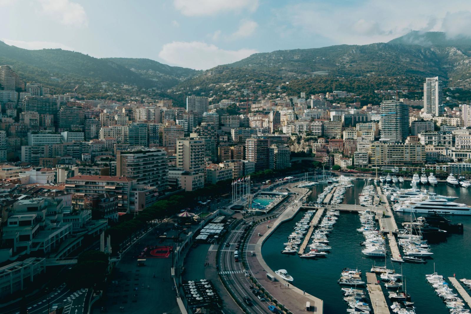 Stunning aerial view of Monaco cityscape with luxury yachts in the harbor under a sunny sky