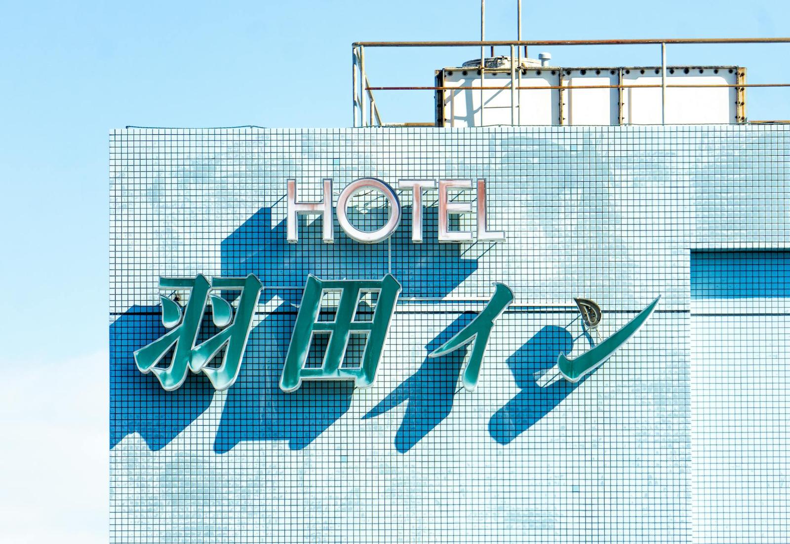 Tiled hotel exterior wall with a large illuminated sign