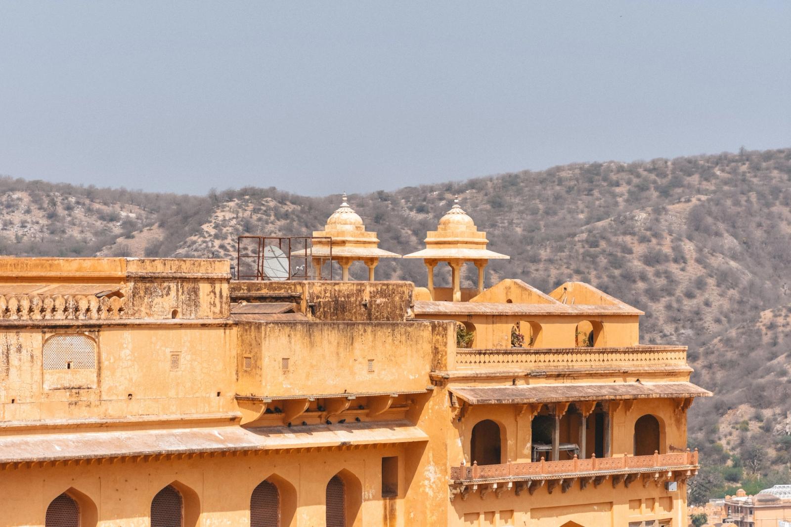 Richly colored historic fort with traditional architecture and mountain backdrop, captured in daylight