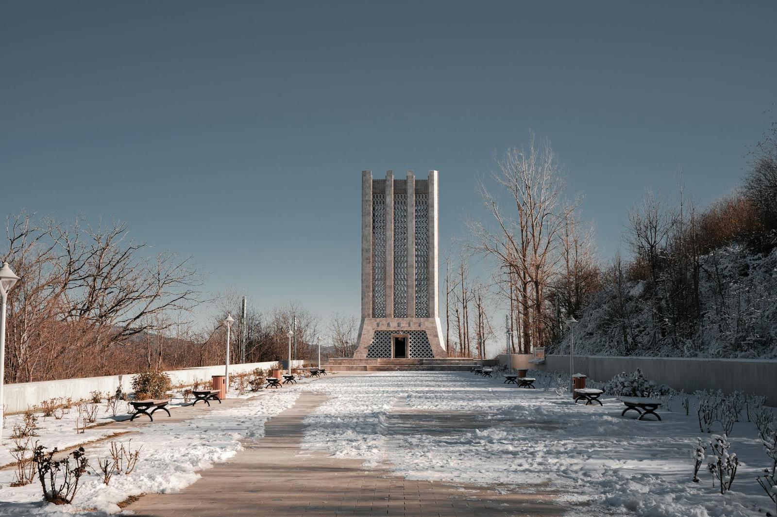 Snow-covered Vagif Mausoleum in a serene park setting, Azerbaijan