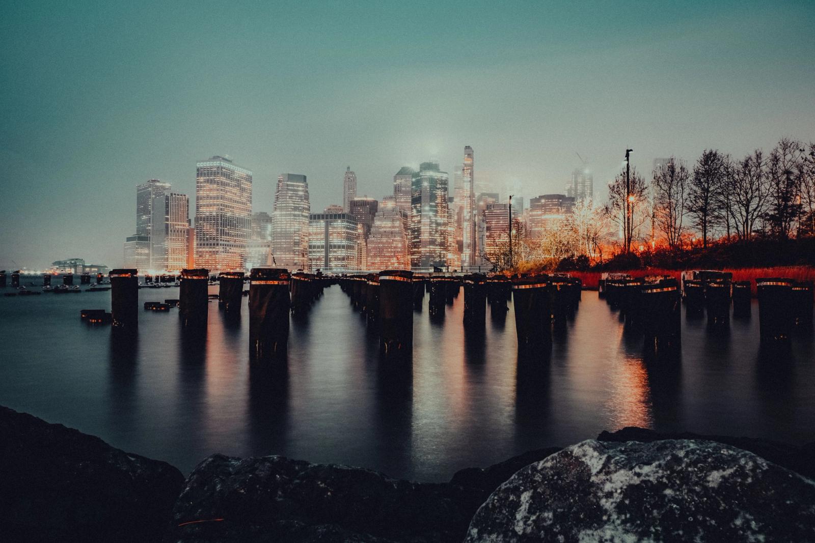 Breathtaking view of New York City's illuminated skyline reflected over the water at night