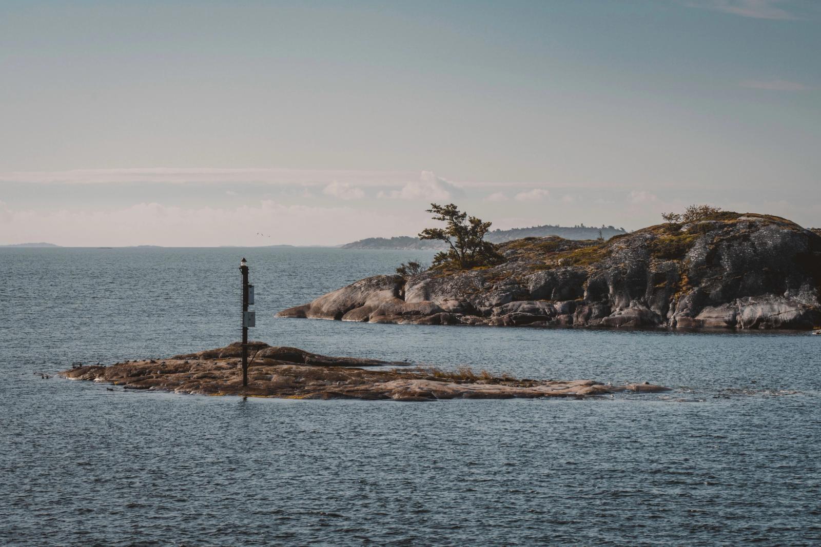 Peaceful seascape with a small rocky island and calm waters, perfect for travel inspiration