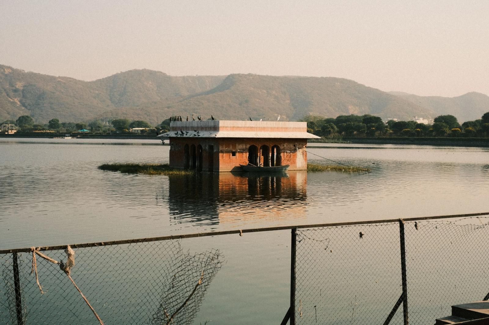 Peaceful view of Jal Mahal surrounded by tranquil water and hills in Jaipur, India