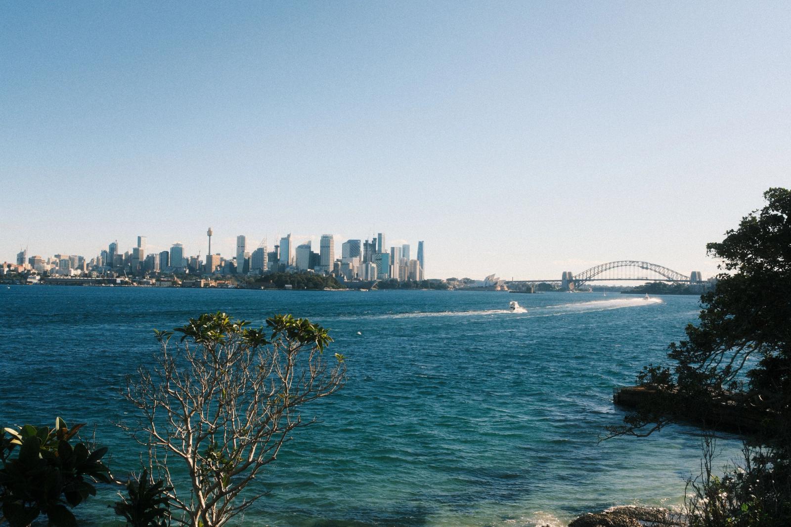 Breathtaking view of Sydney skyline with harbor and famous bridge under a clear blue sky