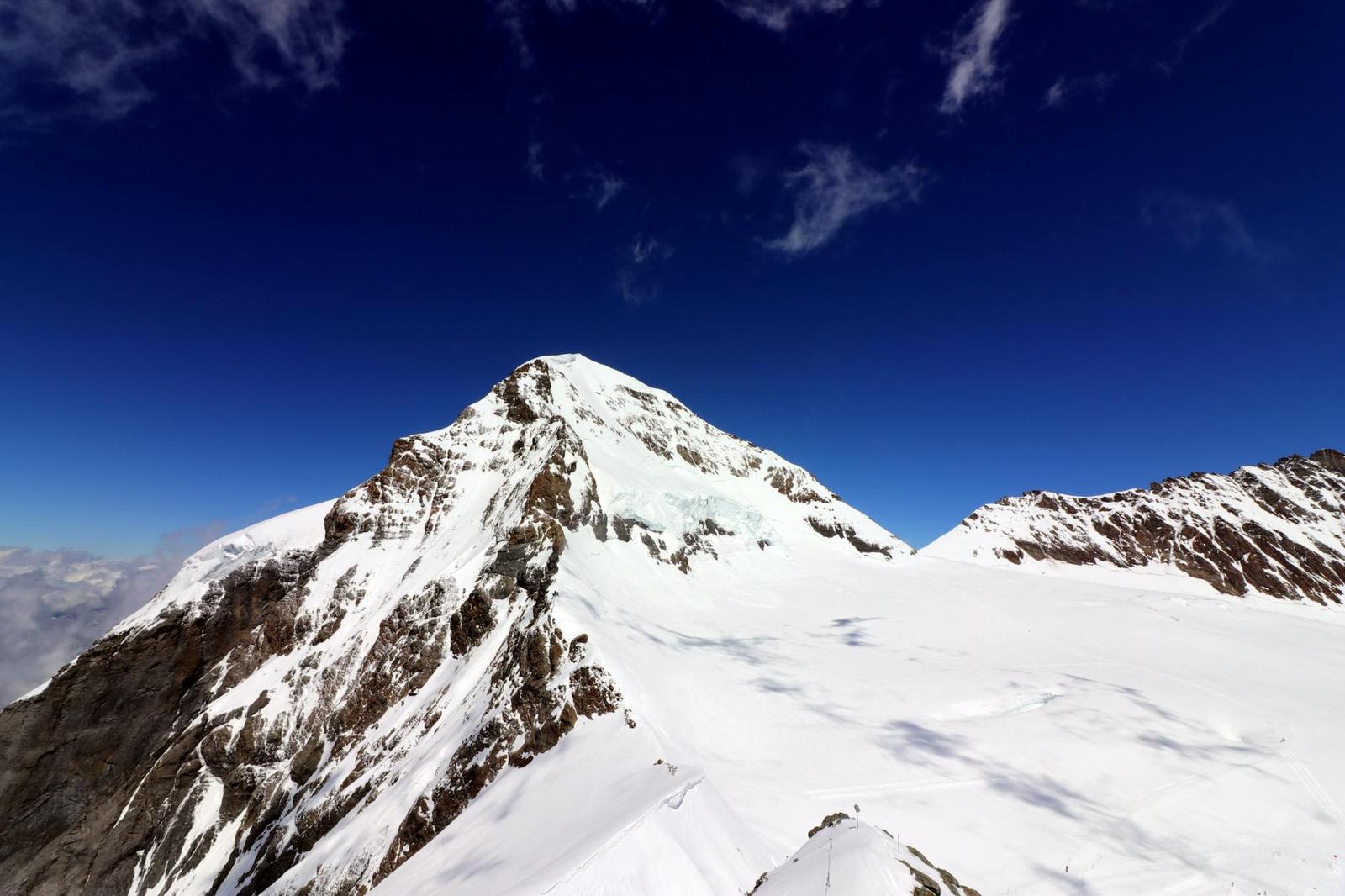 A breathtaking panorama of snow-covered peaks under a clear blue sky in Interlaken, Switzerland