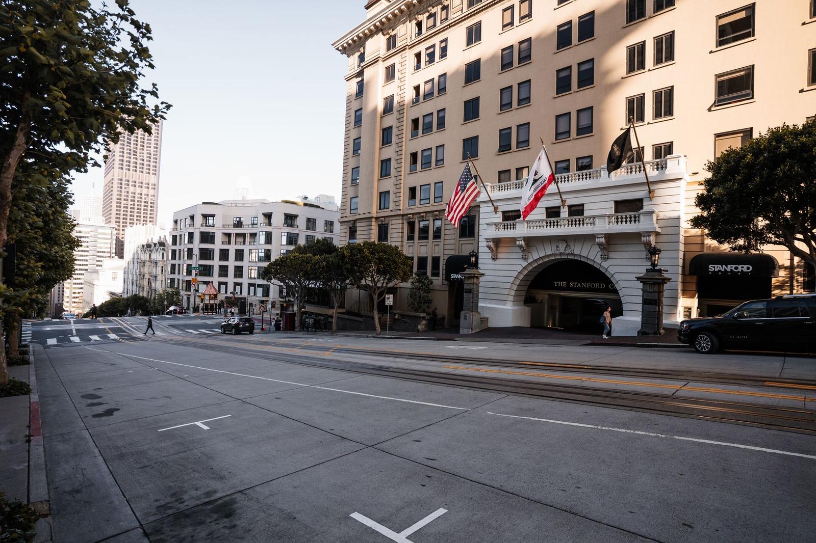 Grand hotel entrance with flags on an empty downtown street