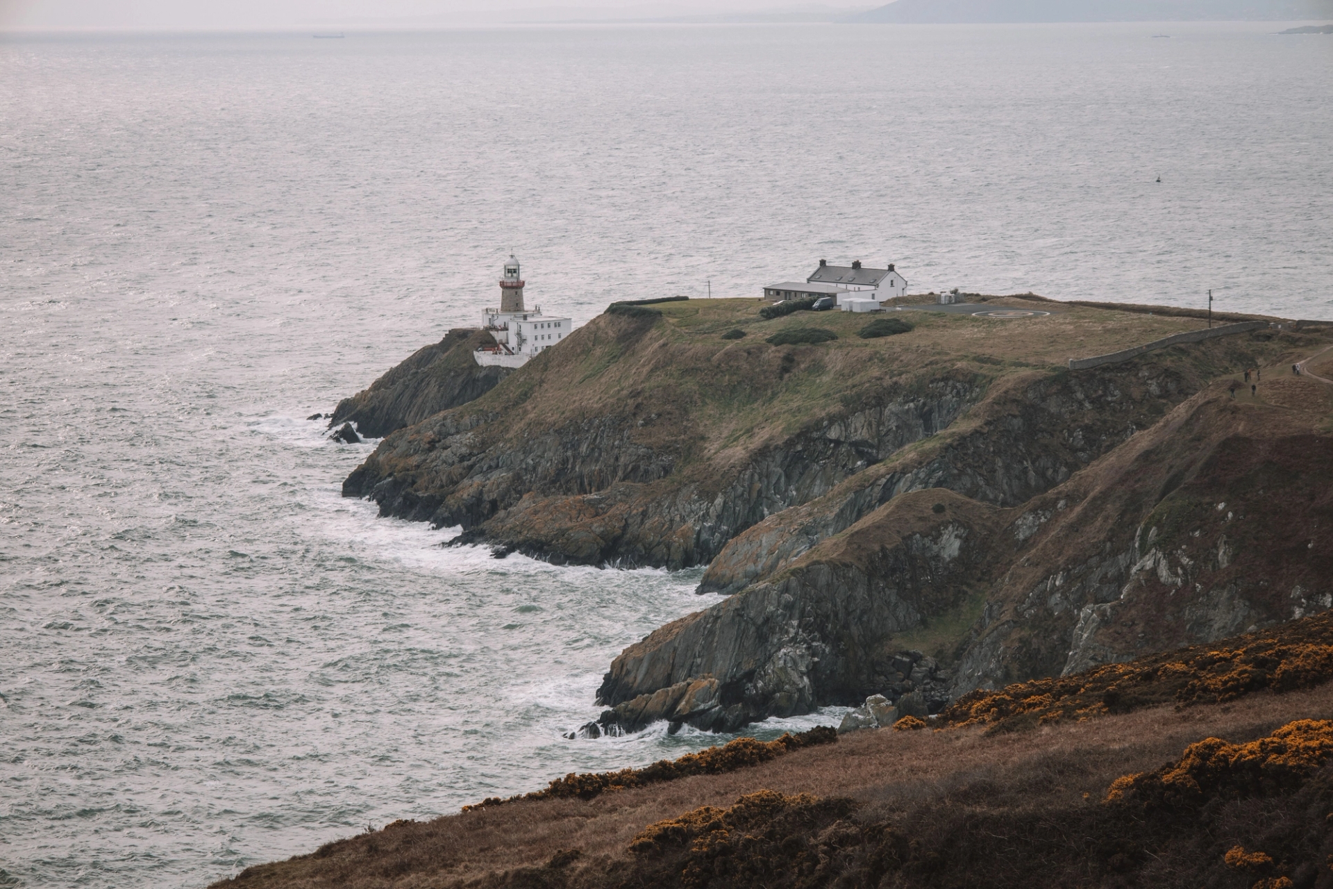 Stunning coastal view of Baily Lighthouse on Howth Head, Dublin, Ireland. Dramatic cliffs meet the vast sea