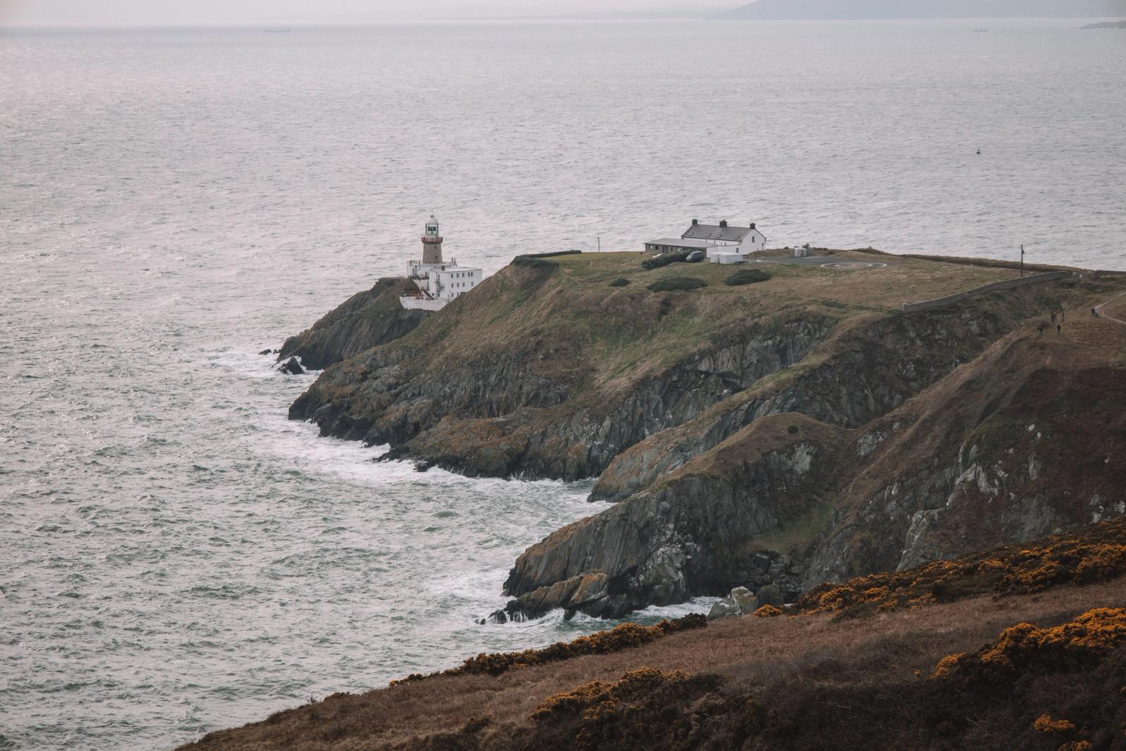 Stunning coastal view of Baily Lighthouse on Howth Head, Dublin, Ireland. Dramatic cliffs meet the vast sea