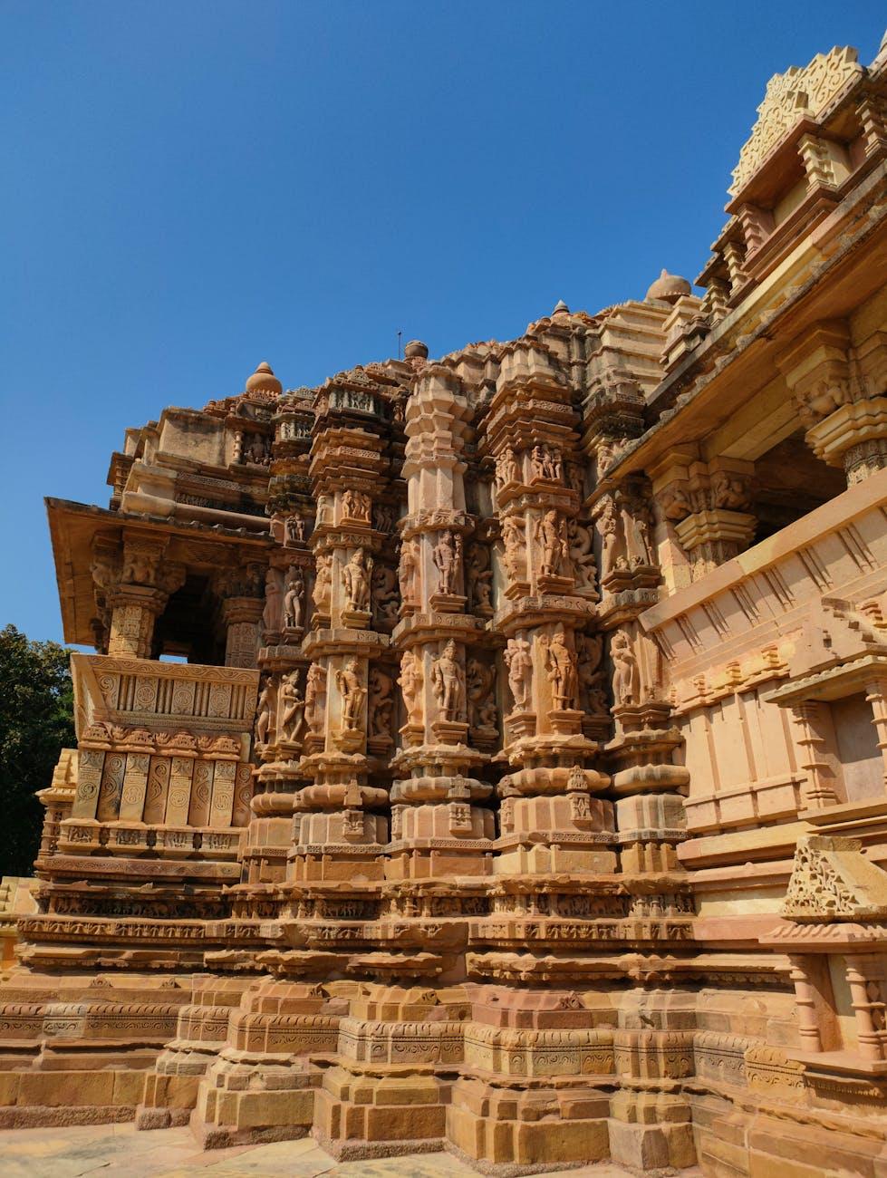 Row of intricately carved stone pillars along a temple facade