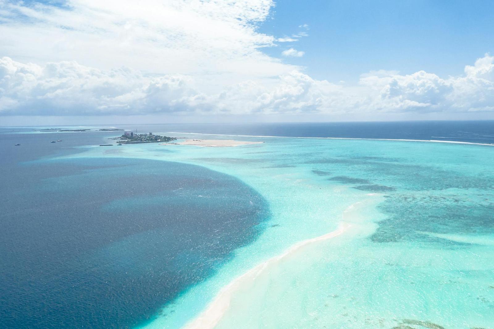 Aerial view of a resort island edged by a deep reef drop-off