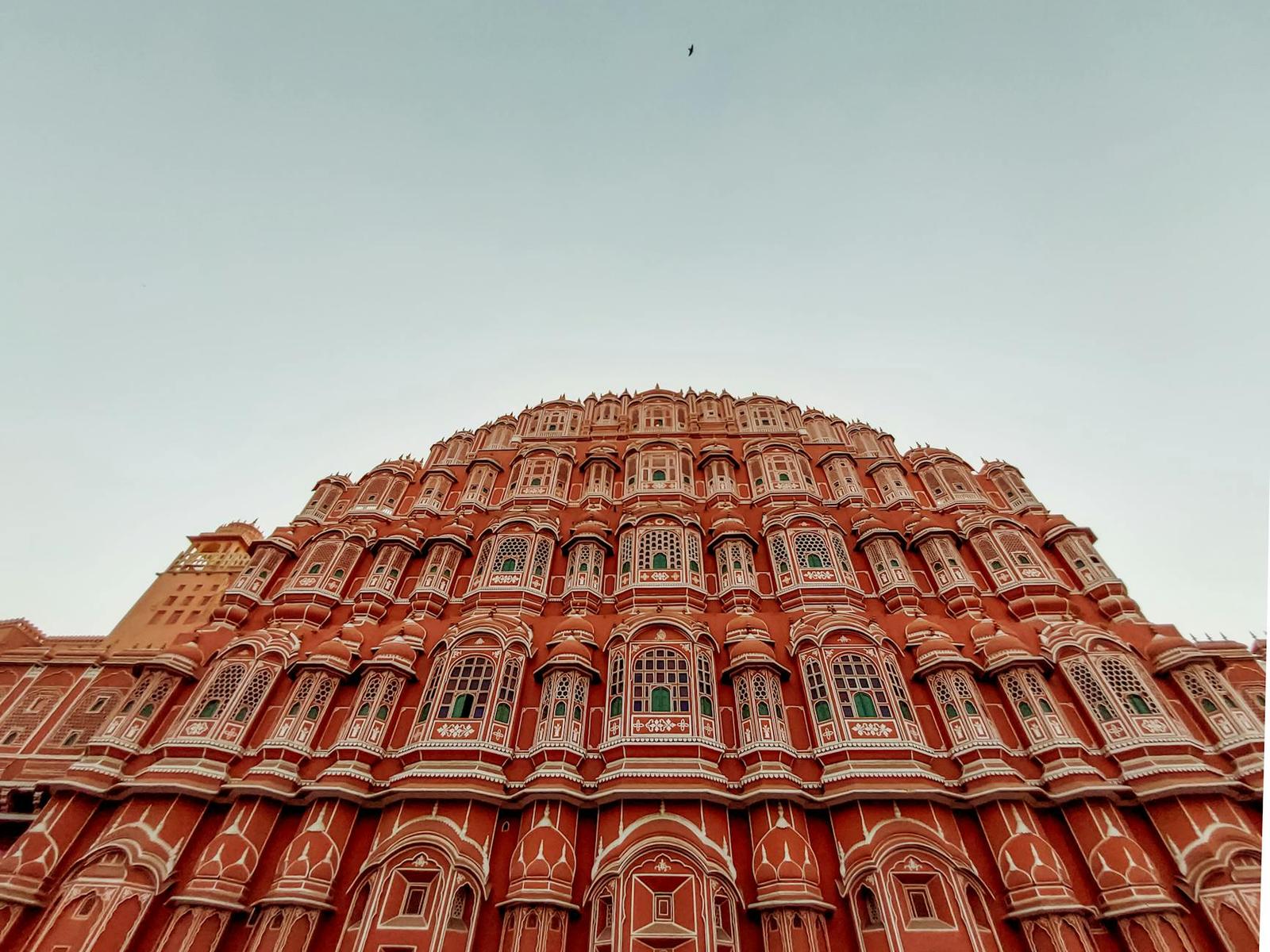 The honeycombed pink facade of Hawa Mahal rising against a pale sky