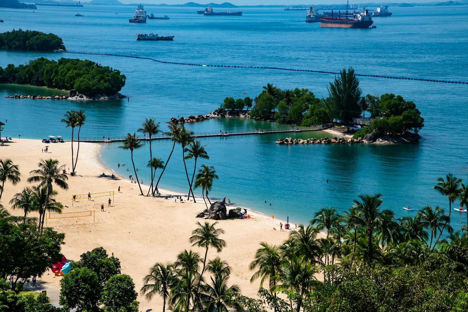 Aerial view of a palm-fringed beach dotted with small islands offshore