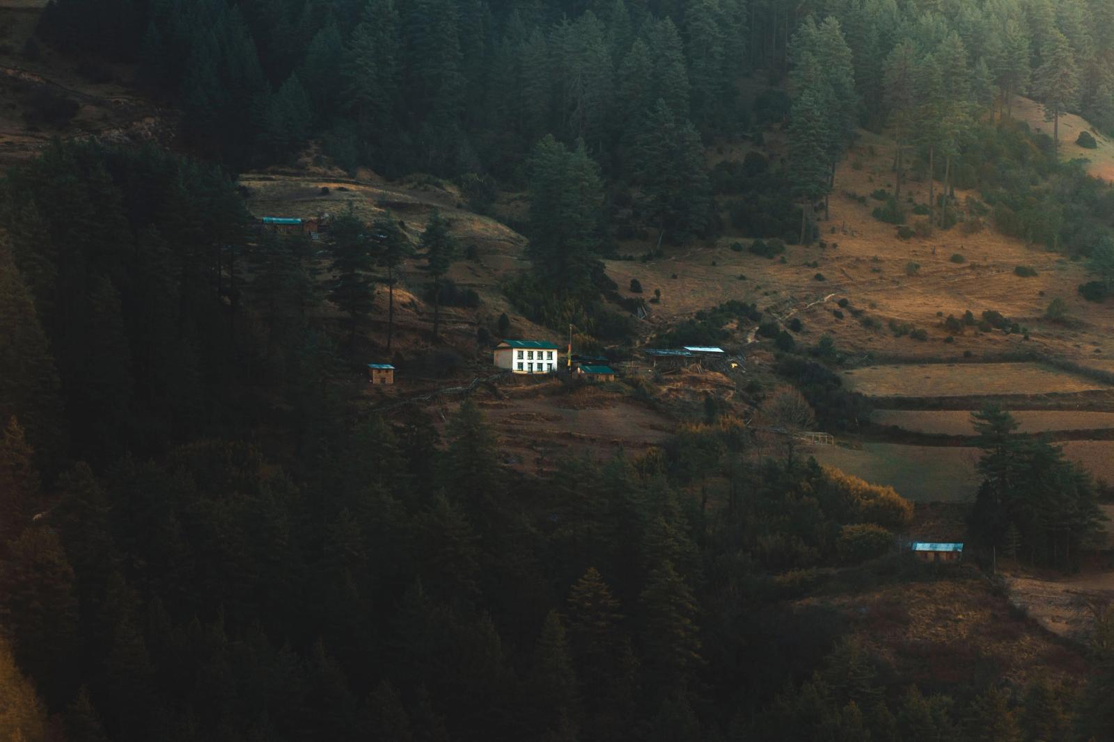 A picturesque rural landscape with a small house amidst dense green forest in Province No. 1, Nepal