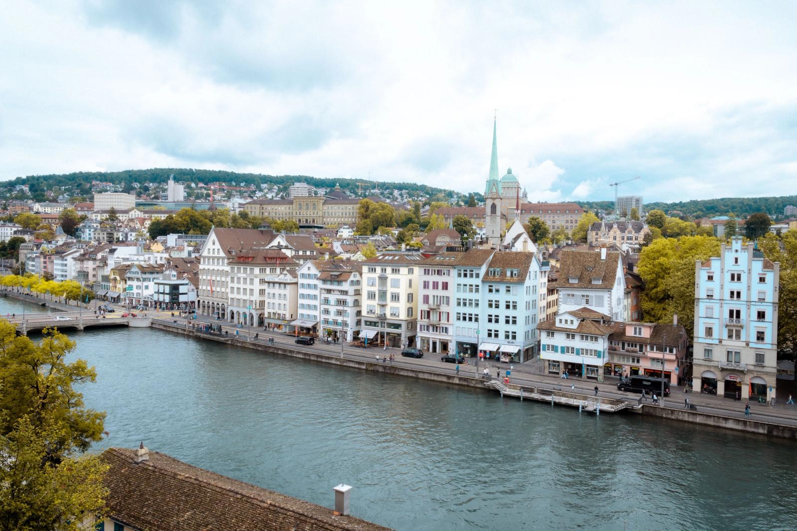 A picturesque view of Zurich's historic buildings along the Limmat River on a cloudy day