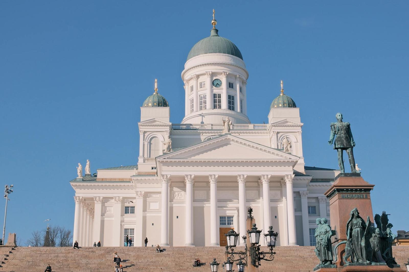 Helsinki Cathedral with blue sky and Alexander II statue in vibrant daylight