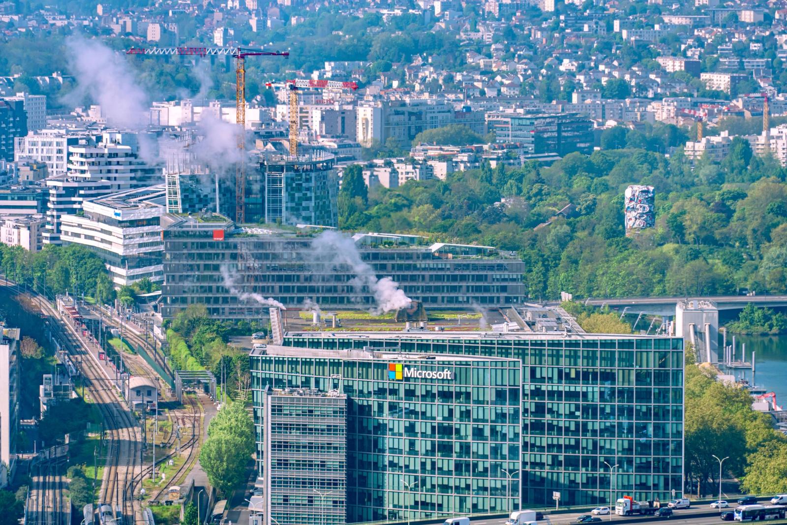 Aerial cityscape featuring the Microsoft Building and Seine River in Paris, showcasing urban architecture and lush greenery