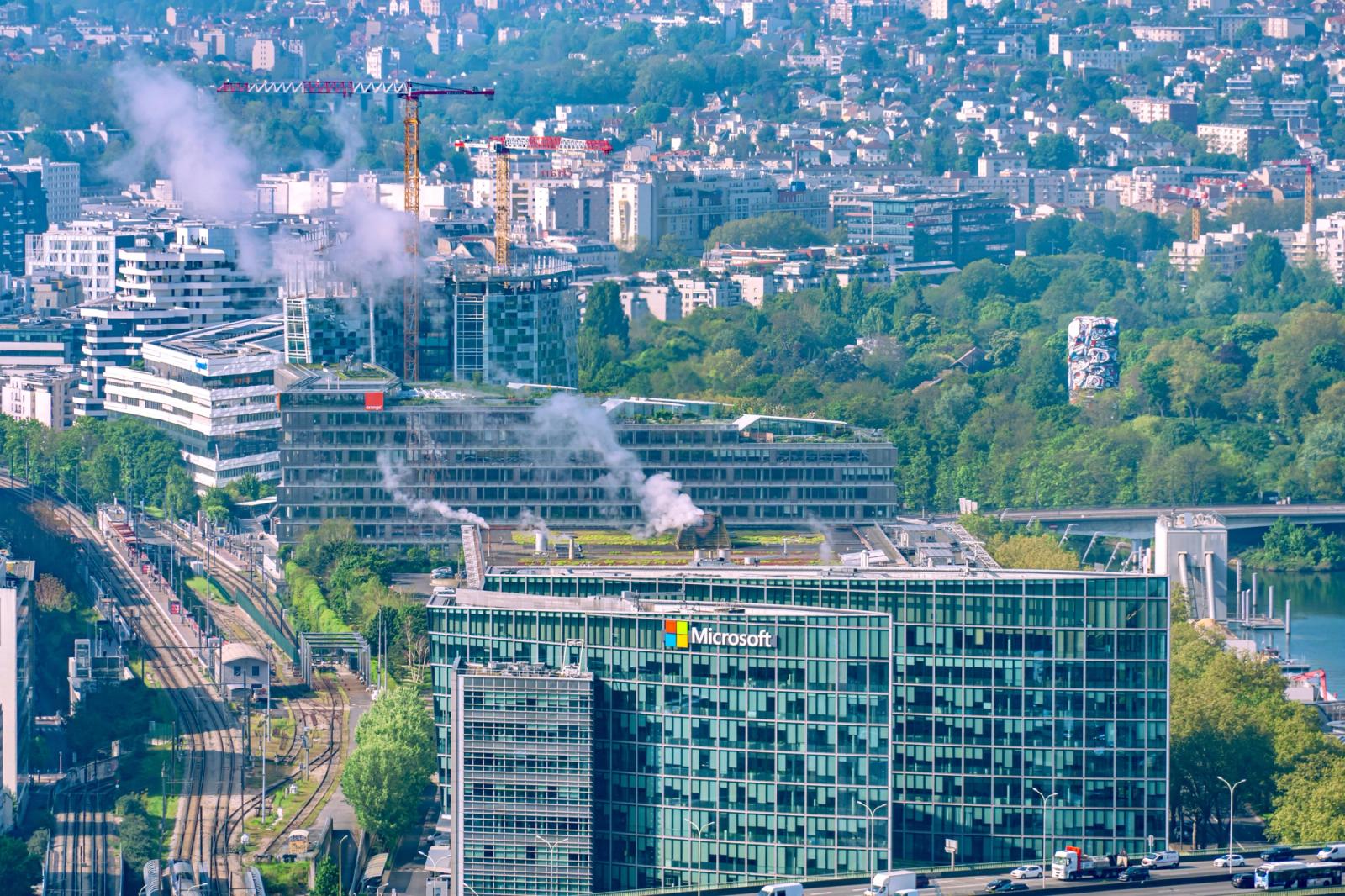 Aerial cityscape featuring the Microsoft Building and Seine River in Paris, showcasing urban architecture and lush greenery